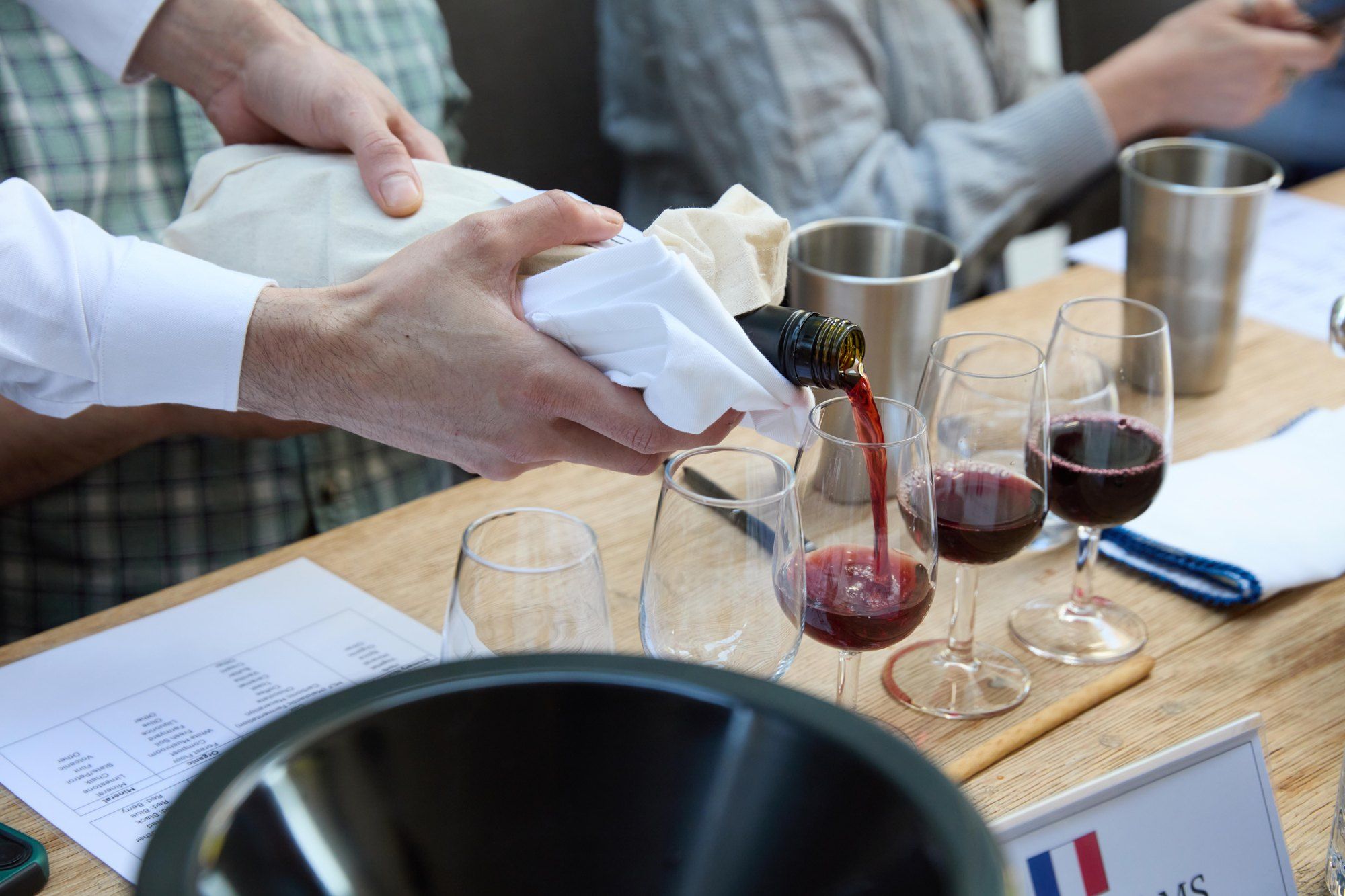 Red wine poured from a wrapped bottle at the panel's blind tasting